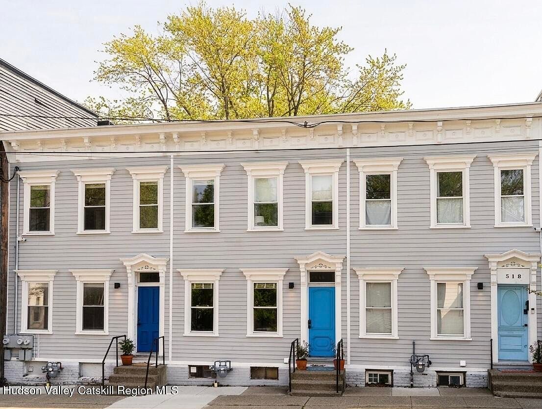 Restored 1910 Federal-style triple townhouse facade with three blue painted front doors at 516-518 State Street, Hudson, New York